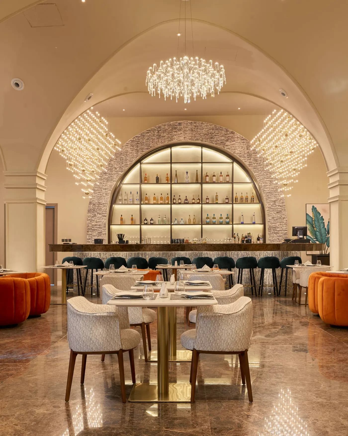 The Havana bar hall — arched spirits display, chandeliers, and orange velvet seating